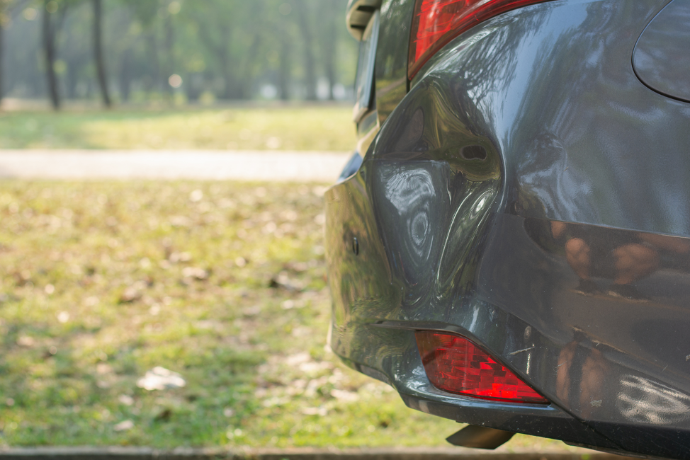 Mid-sized Car With A Large Dent In The Fender